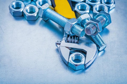 Adjustable key threaded bolt details and screw nuts on metallic background construction concept