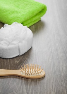 Hairbrush and bath sponge with green towel