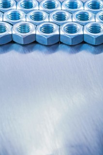 Copyspace image of metal screw nuts on a metallic background Design concept