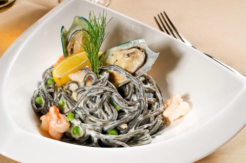 Fresh seafood black squid ink coulored spaghetti pasta tipycal italian food