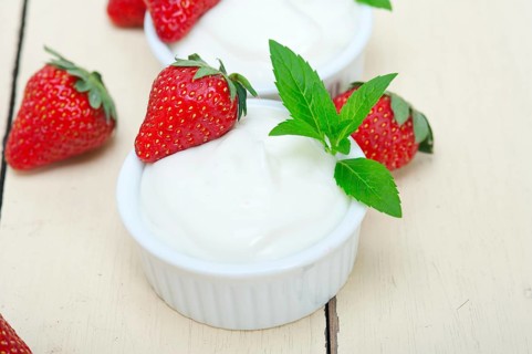 Organic Greek yogurt and strawberry over white rustic wood table