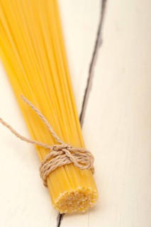 Italian pasta spaghetti tied with a rope on a rustic table