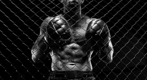 Black and white image of a man in a boxing cage. The concept of sports