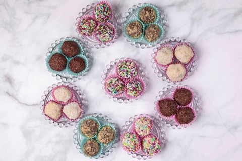 Light and dark rum balls arranged in a circle on glass plates