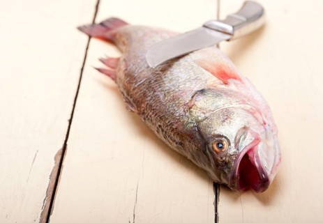 Fresh whole raw fish on a wooden table ready to cook