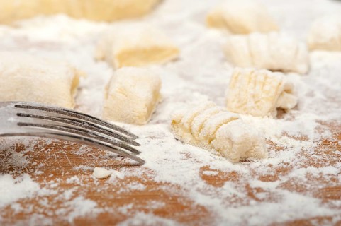 Making fresh Italian potato gnocchi on a wood rustic table