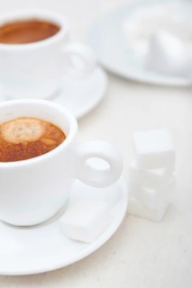 Italian espresso coffee fresh brewed macro closeup with sugar cubes