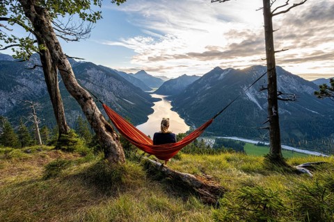 Young woman sitting in an orange hammock