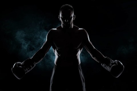 Kickboxer in black gloves posing on a background of smoke. The concept of mixed martial arts. MMA