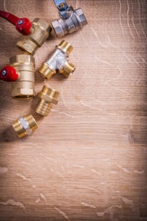 Group Plumbing Items Brass Pipe Connectors On Wooden Board