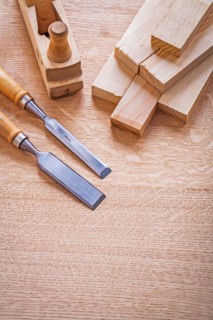 Vertical version composition chisel woodworker level and wooden planks on board construction concept
