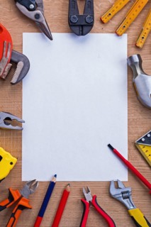 Organised copying surface white paper and cutter metre hammer roller screwdriver pliers pencil tapeline spanner on wooden board