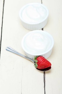 Organic Greek yogurt and strawberry over white rustic wood table