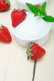 Organic Greek yogurt and strawberry over white rustic wood table