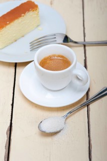 Italian espresso coffee and cheese cake over white wood table