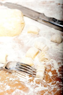 Making fresh Italian potato gnocchi on a wood rustic table