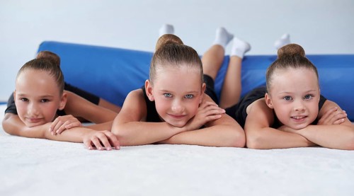 Image of a group of little girls in the gym after a workout. Gymnastics concept. Mixed media