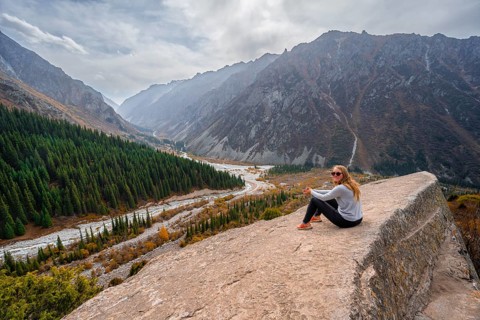 Hiker enjoying the view of the Ala Archa valley from the viewpoint at broken heart rock