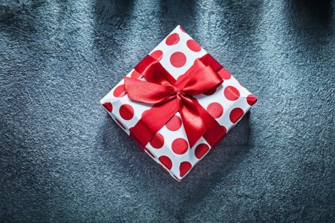 Boxed present with tied bow on black background holidays concept