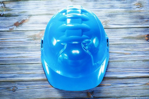 Blue building helmet on vintage wooden board