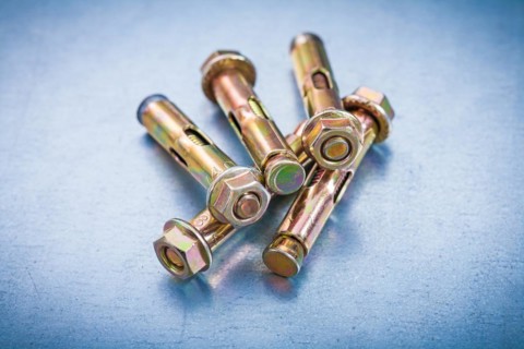 Metallic anchor bolts for concrete walls on a metallic background Repair concept