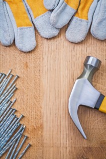 Copyspace image claw hammer nails protective gloves on wooden board