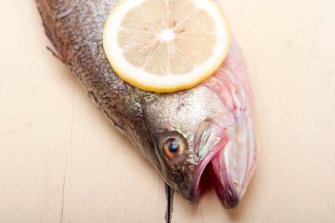 Fresh whole raw fish on a wooden table ready to cook