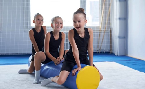 Image of a group of little girls in the gym after a workout. Gymnastics concept. Mixed media