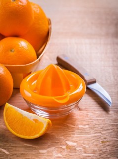 Orange squeezer and fruit knife on wooden table