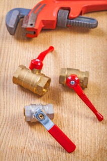 Plumbing accessories and spanners on wooden board