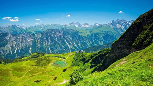 Panorama from the Fellhorn over the Schlappoldsee and Fellhornbahn mountain station to the central main ridge of the Allgaeu Alps