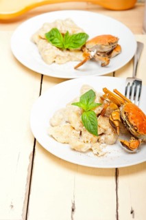 Fresh homemade Italian gnocchi with seafood sauce crab and basil