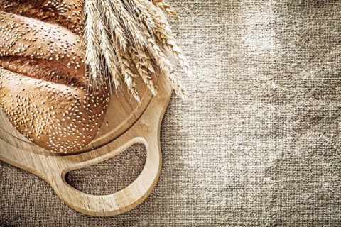 Carving board bread wheat ears on sacking background