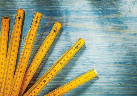 Yellow wooden meter on vintage wood background top view construction concept