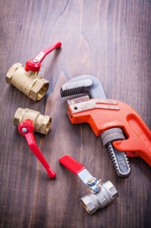 Plumbing accessories and adjustable spanner on an old wooden board