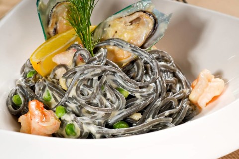 Fresh seafood black squid ink coulored spaghetti pasta tipycal italian food