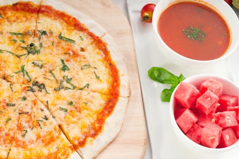 Italian original thin crust pizza Margherita with gazpacho soup and watermelon on side