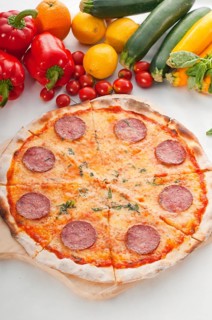 Italian original thin crust pepperoni pizza with fresh vegetables on background