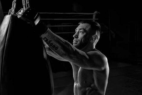 Kickboxer hooks a punching bag to a rope. Sports training. The concept of mixed martial arts. MMA