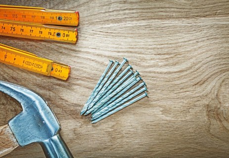 Horizontal image of claw hammer wooden meter construction nails on wood board building concept