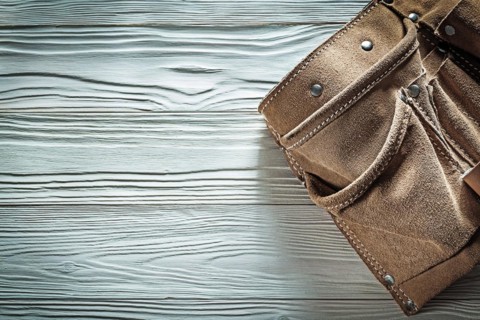 Leather toolbelt on white board copy space