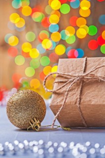 Close up view of vintage paper gift box and gold-coloured Christmas bauble on the table