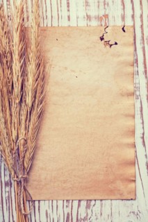 Copyspace background bunch of wheat ears on vintage blanc paper and old wooden board instagram style food and drink concept