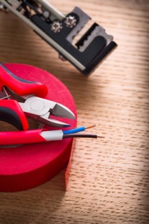 Electric cable pliers Insulating tape Wire stripper on wooden board