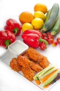 Classic buffalo chicken wings served with fresh pinzimonio and vegetables on background