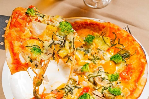 Fresh italian thin style vegetarian pizza with fresh mixed vegetables close up