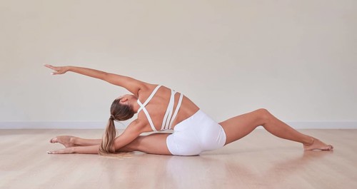 Flexible woman is training in a light studio. The concept of gymnastics