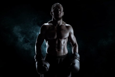 Kickboxer in black gloves posing on a background of smoke. The concept of mixed martial arts. MMA