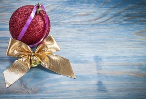 Red Christmas ball golden knot on wooden board holidays concept