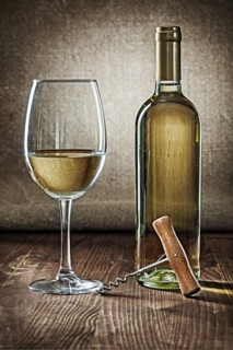 Bottle and glass with white wine and corcksrew